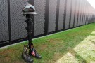 A-helmet-rifle-set-of-dog-tags-and-pair-of-boots-called-a-Fallen-Soldier-Battle-Cross-stands-in-front-of-the-Vietnam-War-Memorial-Wall-rep