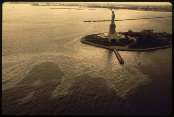 oilslicksurroundsthestatueoflibertyinnewyorkharborfromthesitesexhibitionforotherimagesinthis-nara-553862